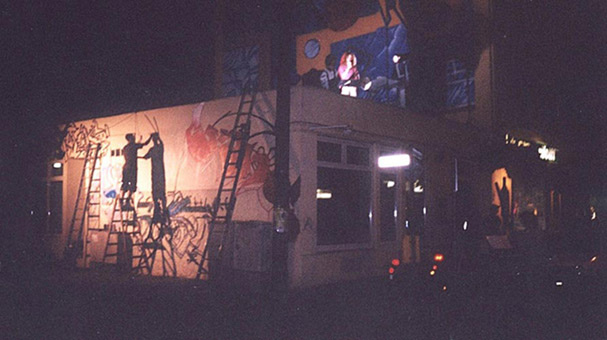 Kunst-und Kulturhappening in der Bremer Neustadt, Buntentosteinweg, Juni 2003. Neben vielen weiteren Künstlern, die Freitag bis Samstag Ihre Fähigkeiten darboten, konnten 4 Graffitimaler einen liveakt bieten. Sinus, Chesko und Siko Ortner fertigten eine gemeinsame Wandgestaltung an. In den Abendstunden wurde mittels Kunstlicht weitergemalt. Samstagabend Minesngerperformance auf dem Dach über den Graffitimalern, 2 Charakter und Siko-style von Siko Ortner, Sinus-style von Sinus und Chesko-style von Chesko. fest05