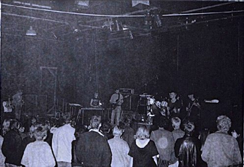 Kunsthappening Herbstens in Hamburg St.Pauli im Oktober 1990. Projektorganisation neben weiteren Ines Ortner/Rapunzel für deren Band Mixed Double, Siko Ortner ein Aerosolart auf Leinwand fertiggestellt hat. Die Leinwand die Ausgeglichenheit aus der Themenreihe Emotionen ist mit Sprühlack auf Leinwand gearbeitet, 1,15 m X 1,90 m fertiggestellt im Oktober 1990. Foto vom Musikliveauftritt (Foto vom Veranstalter).