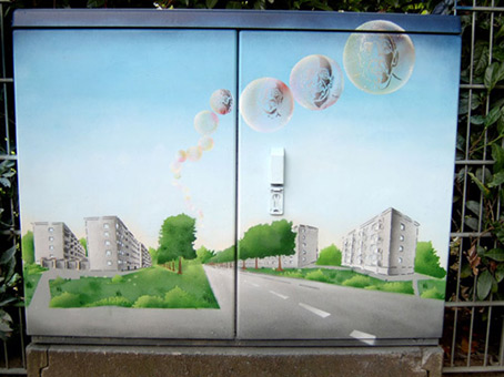 Aktiv für die Vahr. Ein Projekt von JUS, Bremen (die Maulwürfe) vom Oktober bis November 2007. Die Graffitiwerkstatt wurde durchgeführt von Siko Ortner als offenes Atelier für Jugendliche aus dem Stadtteil. Außerdem waren täglich bis zu 5 Kursteilnehmer direkt von JUS dabei. Der fertiggestellte Stromkaste 01 ergänzt durch die Seifenblasen mit Stancelporträts von 4 JUS Mitarbeitern. Kunst im öffentlichen Raum. Stancelart / Schablonengraffiti auf einem Stromkasten in der Neuen Vahr in Bremen.