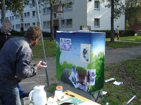 Aktiv für die Vahr. Ein Projekt von JUS, Bremen (die Maulwürfe) vom Oktober bis November 2007. Die Graffitiwerkstatt wurde durchgeführt von Siko Ortner als offenes Atelier für Jugendliche aus dem Stadtteil. Außerdem waren täglich bis zu 5 Kursteilnehmer direkt von JUS dabei. Nachdem der Backround fertiggestellt wurde folgen nun die A4 großen Stancelgemälde.  Kunst im öffentlichen Raum. Stancelart / Schablonengraffiti auf einem Stromkasten in der Neuen Vahr in Bremen.