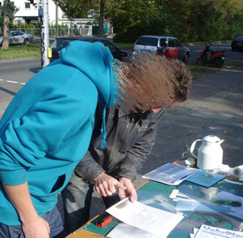 Aktiv für die Vahr. Ein Projekt von JUS, Bremen (die Maulwürfe) vom Oktober bis November 2007. Die Graffitiwerkstatt wurde durchgeführt von Siko Ortner als offenes Atelier für Jugendliche aus dem Stadtteil. Außerdem waren täglich bis zu 5 Kursteilnehmer direkt von JUS dabei. Hier werden die Details für ein Stancelporträts auf der Seite besprochen. Kunst im öffentlichen Raum. Stancelart / Schablonengraffiti auf einem Stromkasten in der Neuen Vahr in Bremen.