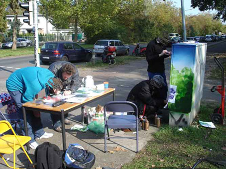 Aktiv für die Vahr. Ein Projekt von JUS, Bremen (die Maulwürfe) vom Oktober bis November 2007. Die Graffitiwerkstatt wurde durchgeführt von Siko Ortner als offenes Atelier für Jugendliche aus dem Stadtteil. Außerdem waren täglich bis zu 5 Kursteilnehmer direkt von JUS dabei. Hier werden die Details für ein Stancelporträts auf der Seite besprochen. Kunst im öffentlichen Raum. Stancelart / Schablonengraffiti auf einem Stromkasten in der Neuen Vahr in Bremen.