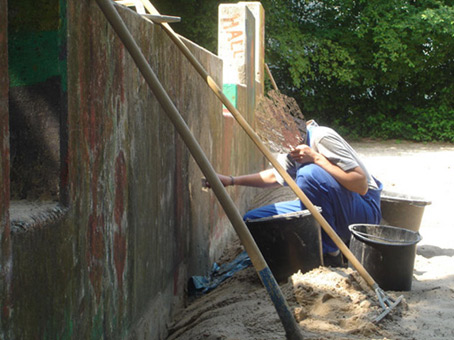 Die Mauer muß weg. Ein Projekt von JUS, Neue Vahr Bremen (die Maulwürfe) vom August bis Mitte September 2007. Hier die Renovierung der Mauer durch Teilnehmer des JUS Programmes für die Bemalung durch die Graffitikursteilnehmer von Siko Ortner.